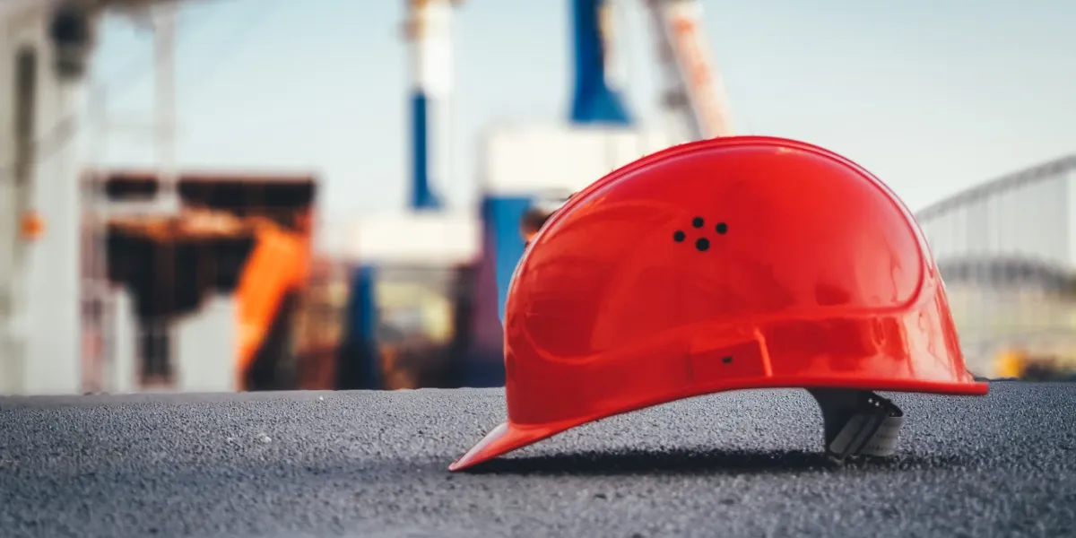 Red safety helmet on pavement