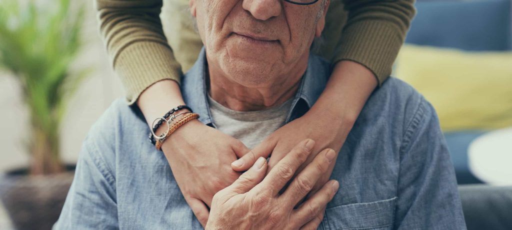 Comforting hand on shoulder of man