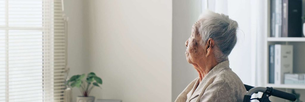 Older Lady Looking Off in the Distance in Wheelchair in a Nursing Home