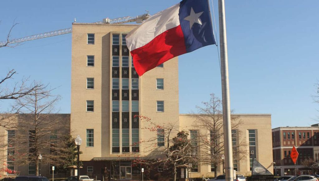 Tyler, Texas Smith County Courthouse Front Entrance with Texas Flag in Foreground